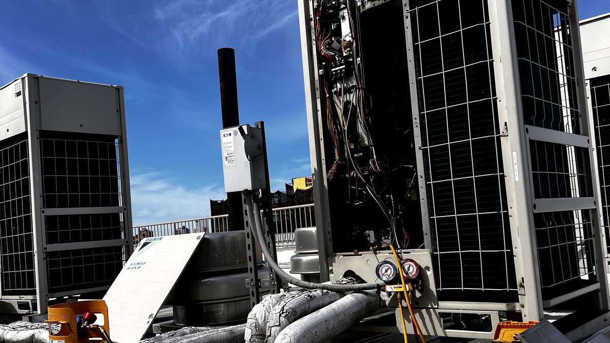 Commercial rooftop HVAC diagnostic work with gauges and service tools